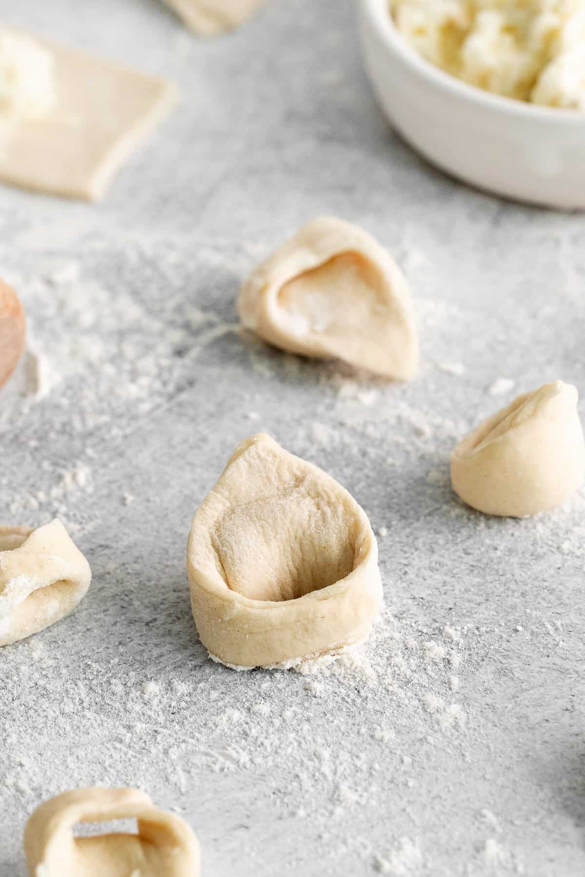 homemade tortellini on cutting board.