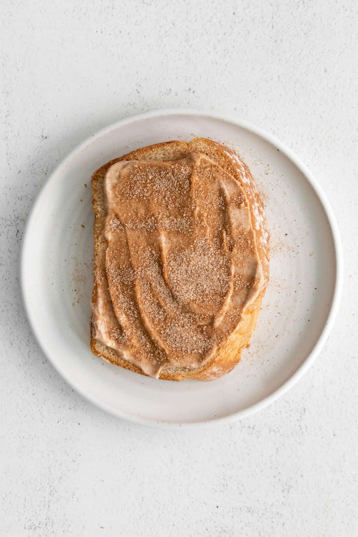 Bread with cream cheese and cinnamon on top.