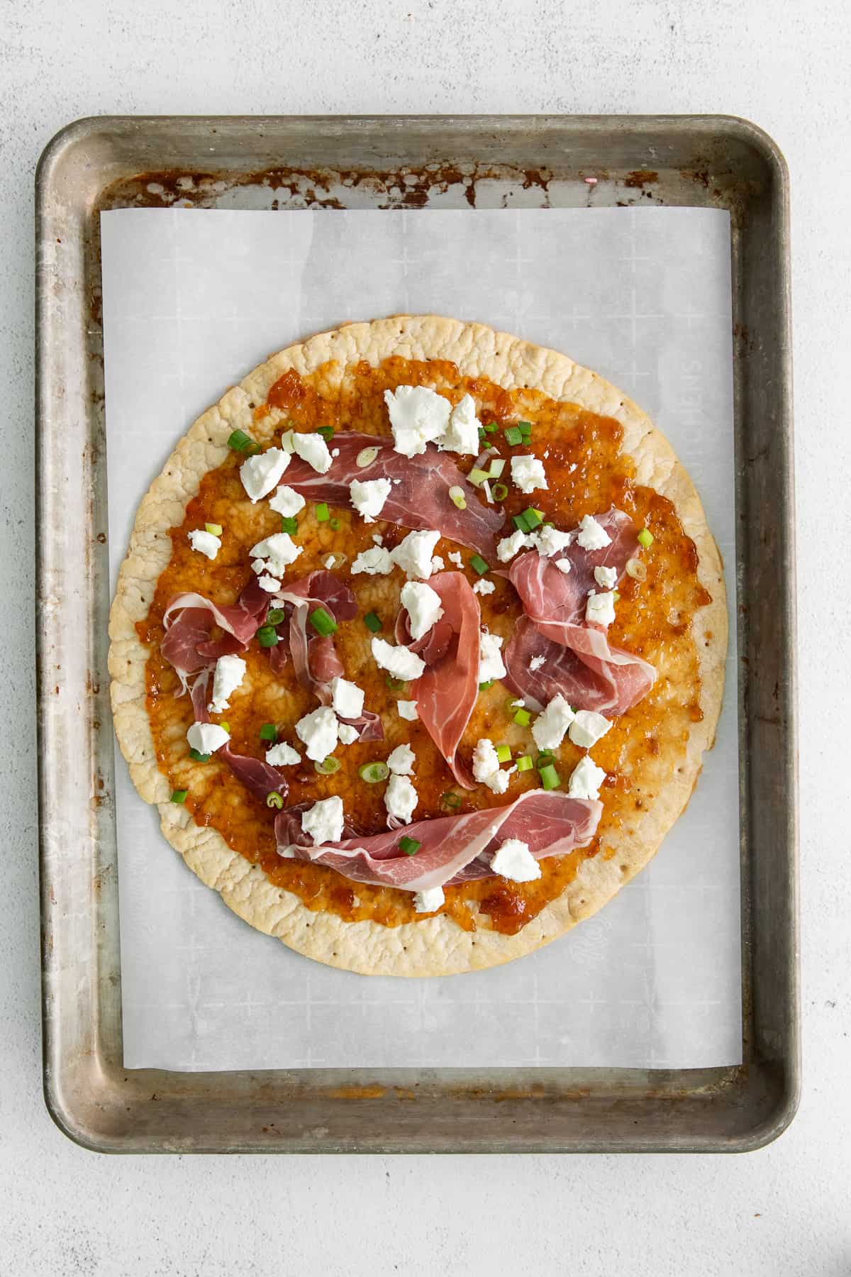 Fig and goat cheese flatbread on a baking sheet.