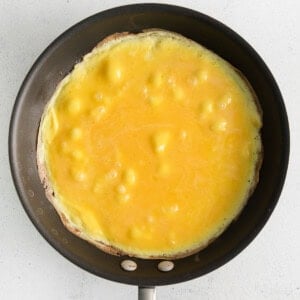 Whisked eggs in a skillet.