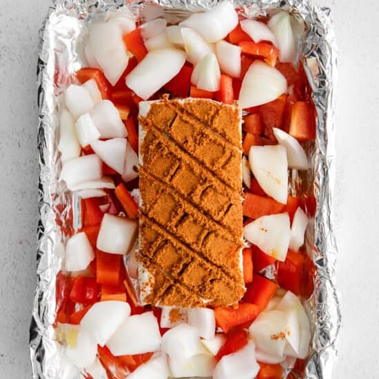 a sheet of foil with a piece of meat and vegetables on it.