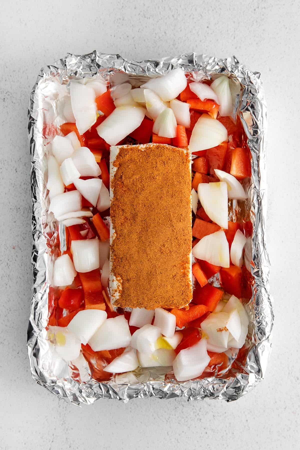 Smoked cream cheese on a tin foil boat surrounded by veggies.