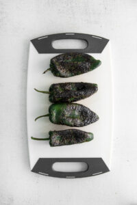 charred peppers on cutting board.
