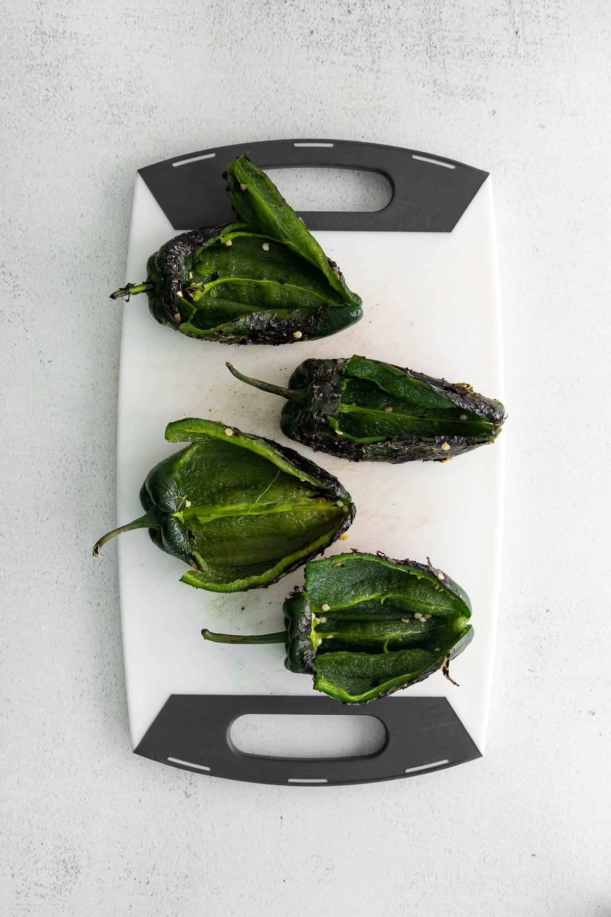 Seeded poblano peppers on a cutting board. 