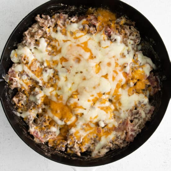 Melted cheese on top of cheeseburger dip.