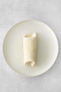 rolled burrito on plate.