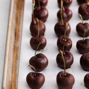 Chocolate covered cherries on parchment paper.