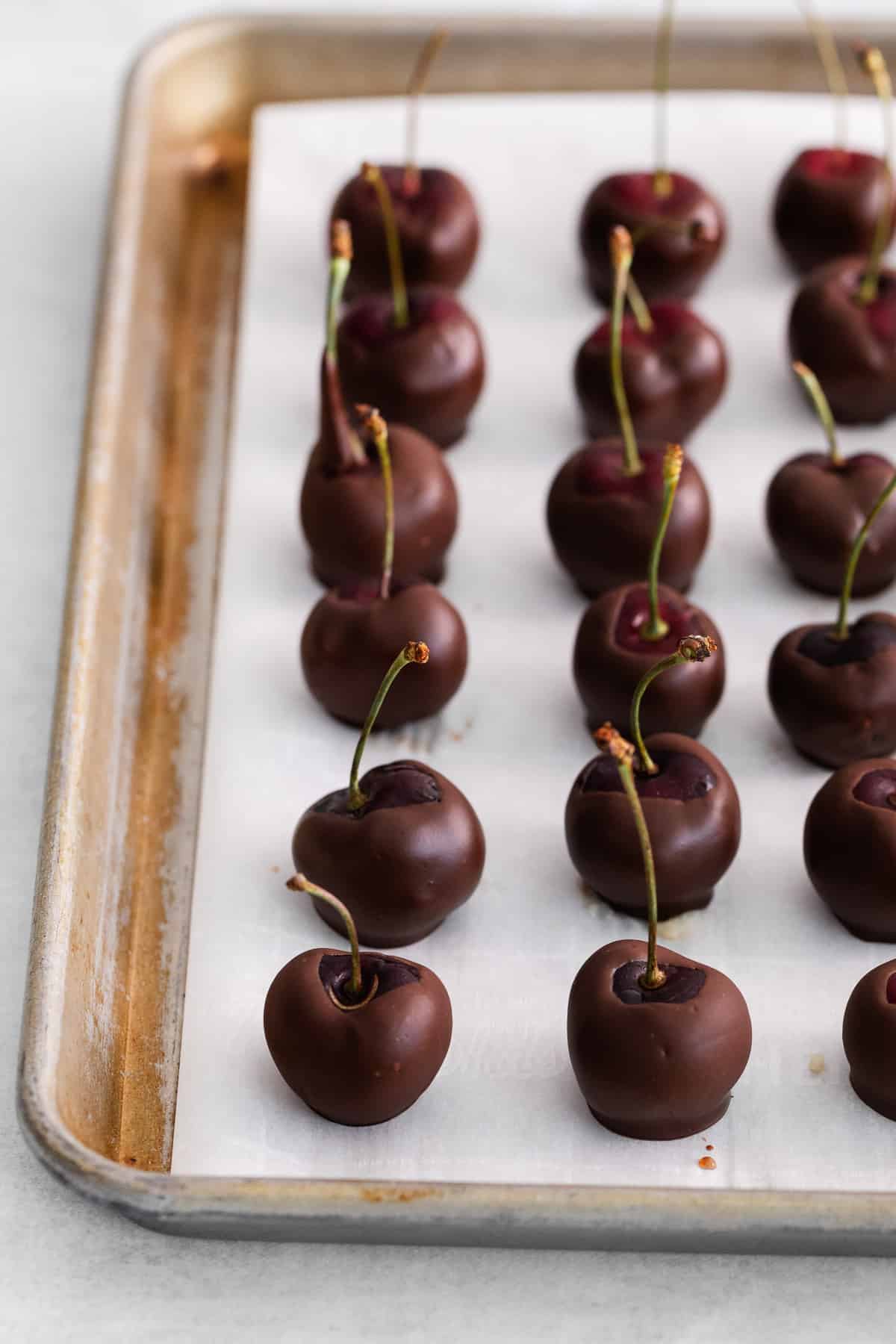 Chocolate covered cherries on parchment paper.
