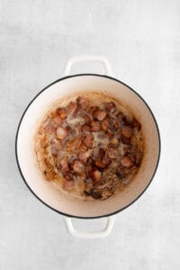a pot with bacon in it on a white background.