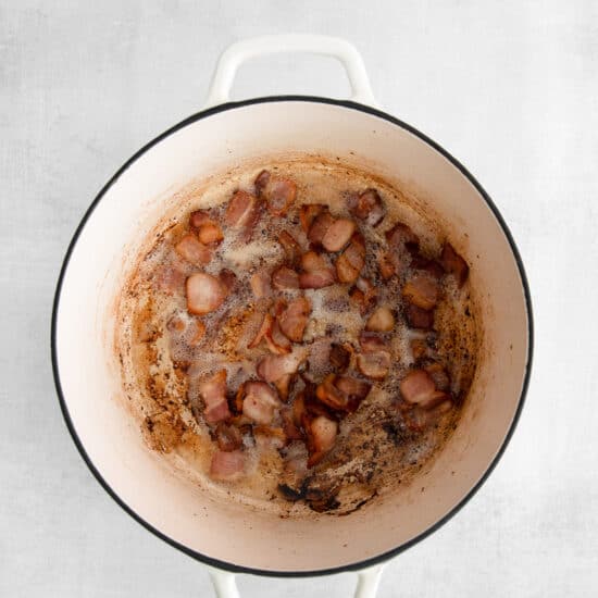 a pot with bacon in it on a white background.