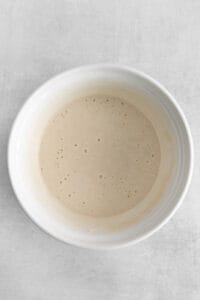 a white bowl with a white liquid in it.