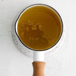 Simmering garlic butter sauce in a small saucepan.