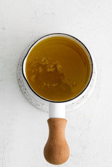 Simmering garlic butter sauce in a small saucepan.