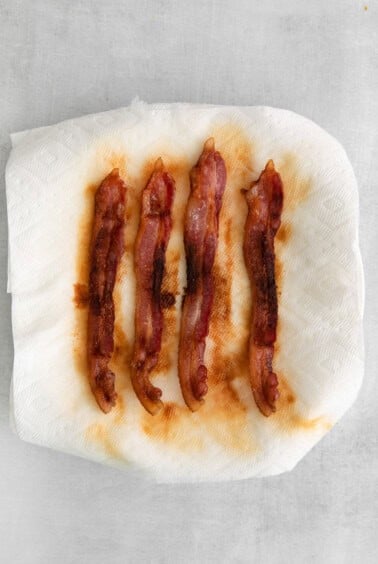 bacon wrapped in paper on a white surface.