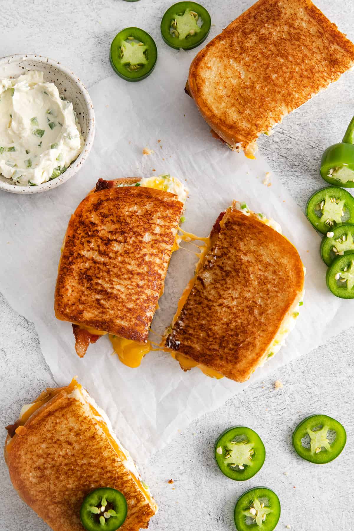 Jalapeno popper grilled cheese sandwich sliced in half.