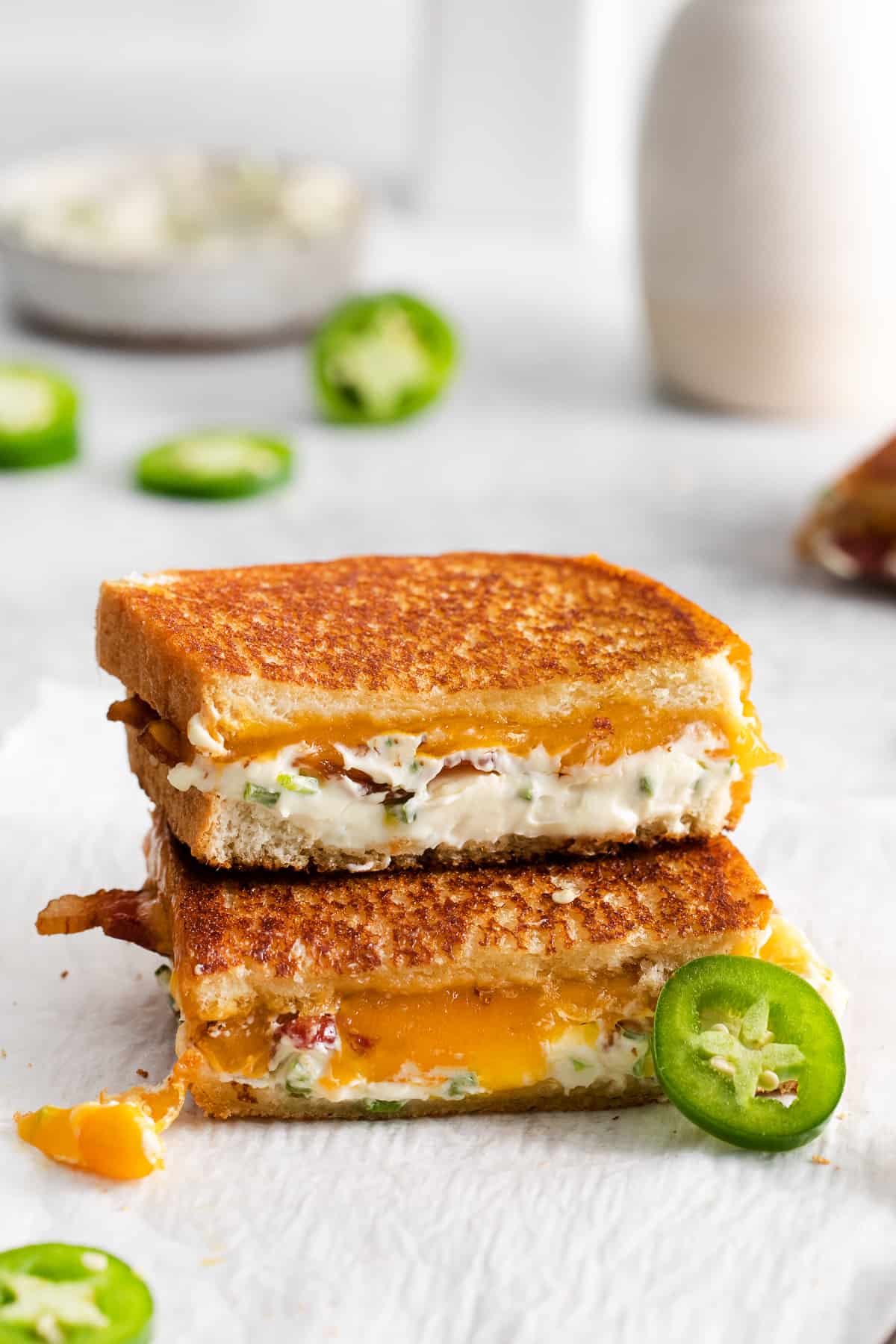 Jalapeno popper grilled cheese stacked on a plate.