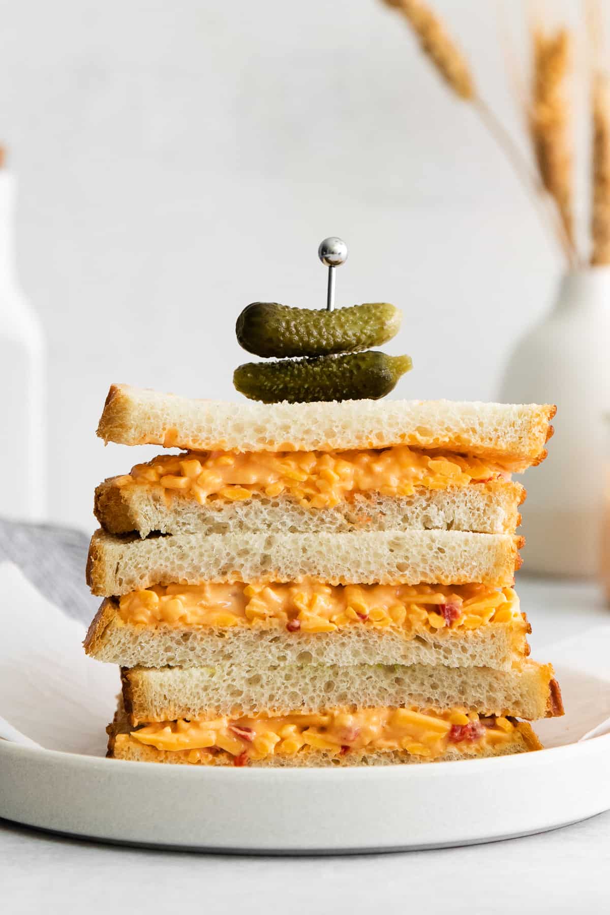 A stack of pimento cheese sandwiches on a plate. 