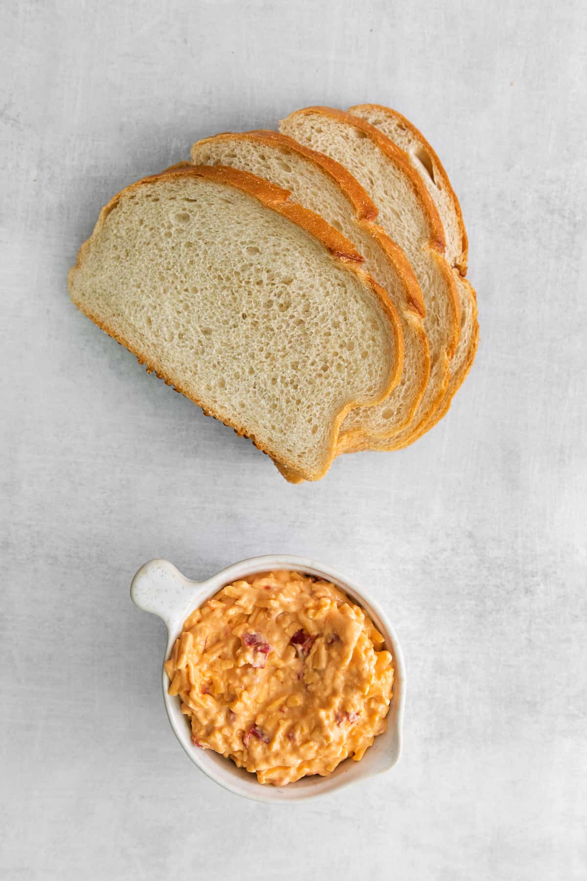 Bread and pimento cheese on the counter. 