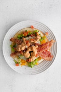 a plate with bacon, lettuce and tomatoes on it.