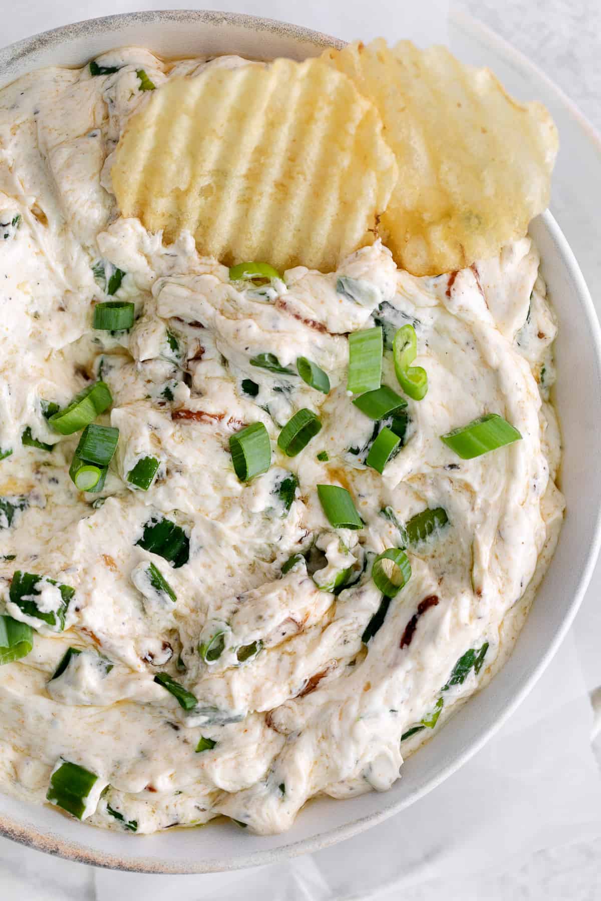 scallion dip in bowl with chips
