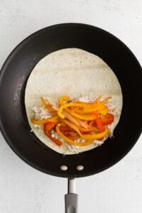 a tortilla is being cooked in a frying pan.