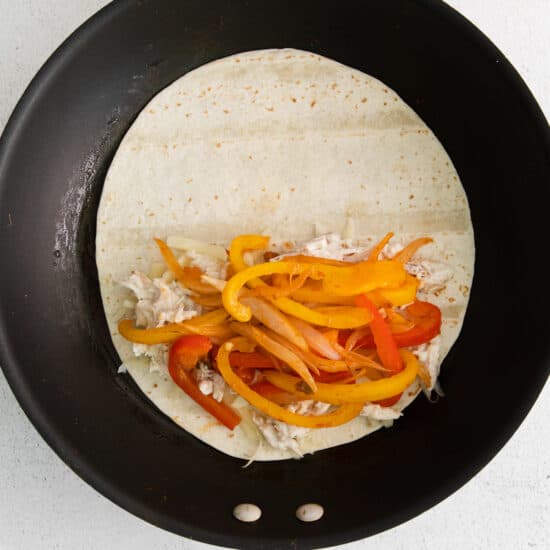 a tortilla is being cooked in a frying pan.