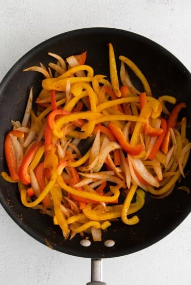 fried peppers in a frying pan on a white background.