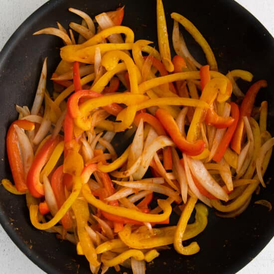 fried peppers in a frying pan on a white background.