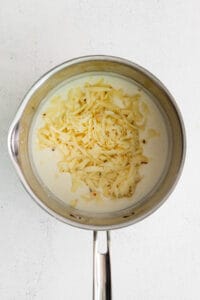 a pan with cheese in it on a white background.