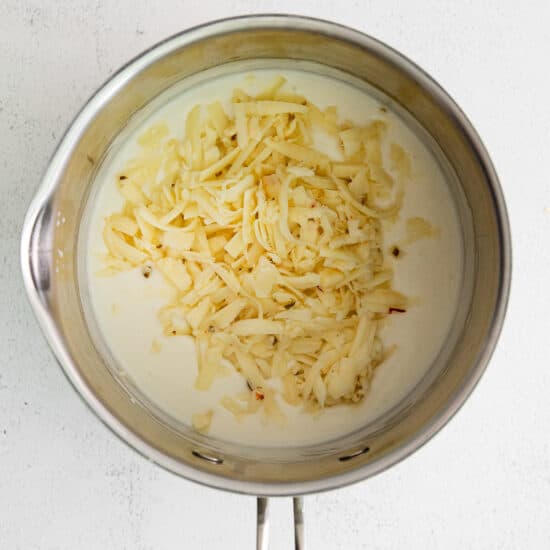 a pan with cheese in it on a white background.