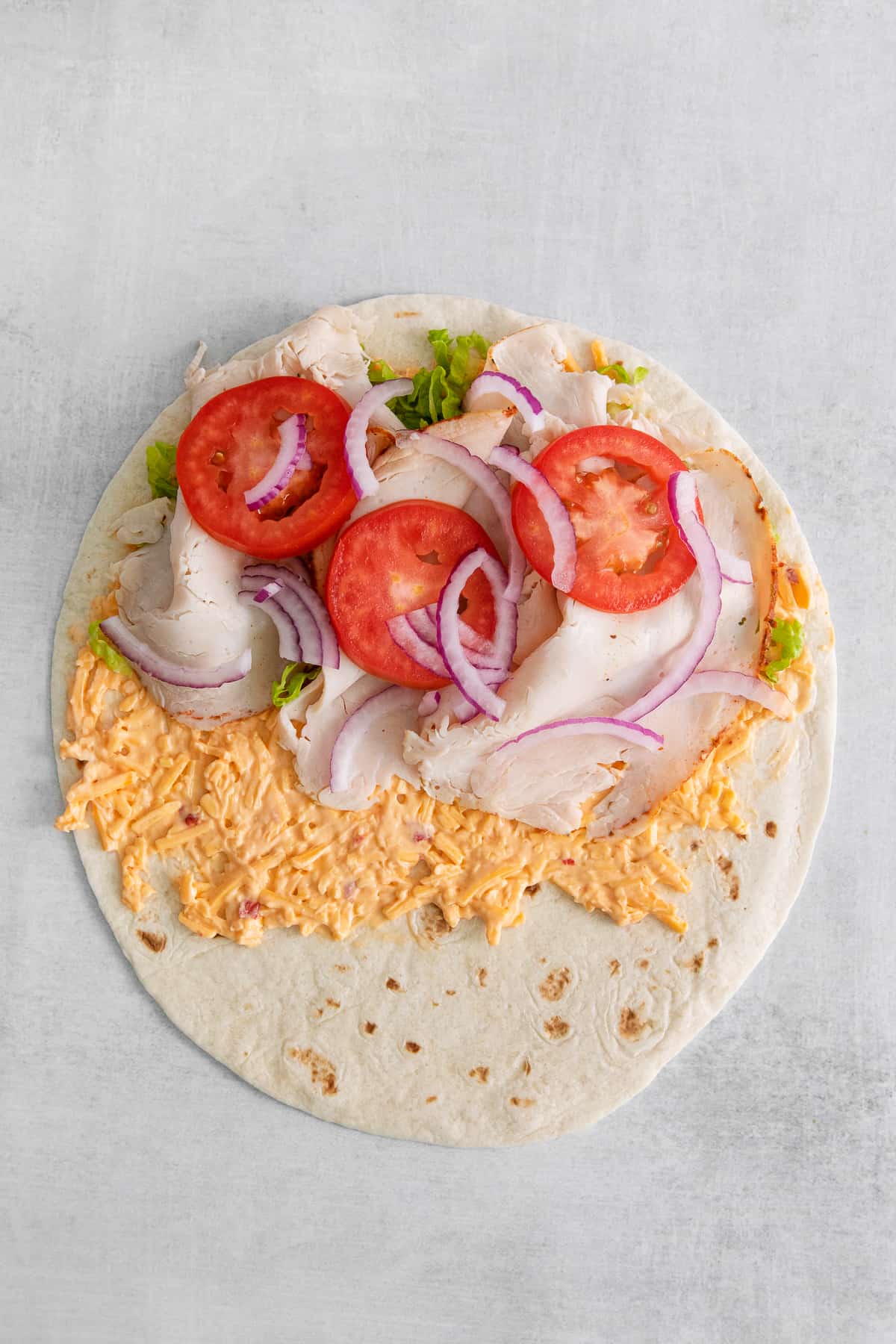 Turkey, onion, and turkey on top of the tortilla.