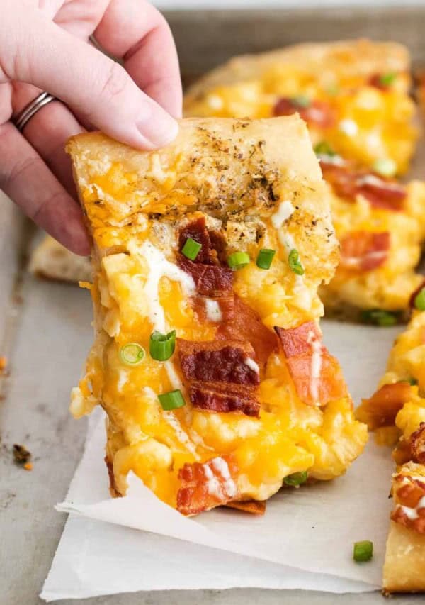 hand holding pizza.