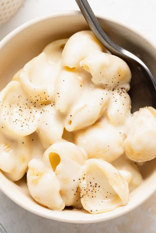 White cheddar mac and cheese served in a bowl with a spoon.
