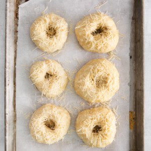 uncooked bagels on baking sheet.