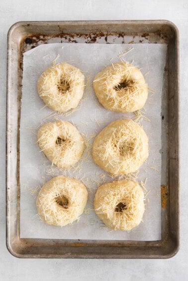 uncooked bagels on baking sheet.