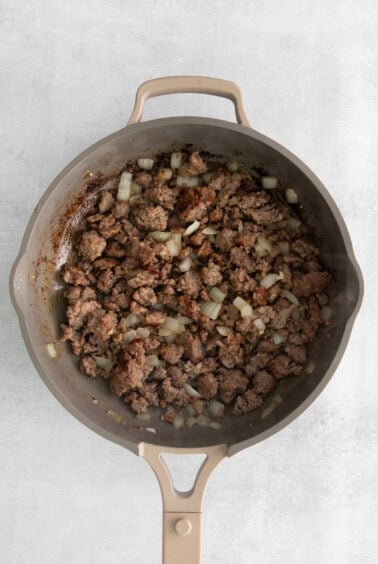 cooking sausage in pan.