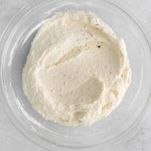 whipped cream in a glass bowl on a white background.