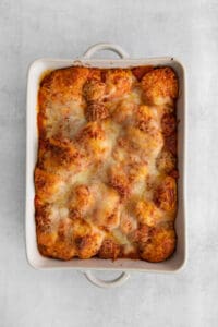 a white casserole dish with a dish of pasta and cheese.