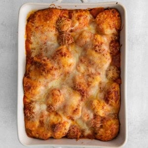 a white casserole dish with a dish of pasta and cheese.