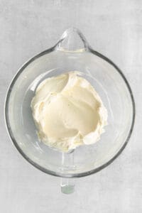 a glass bowl filled with cream on top of a table.
