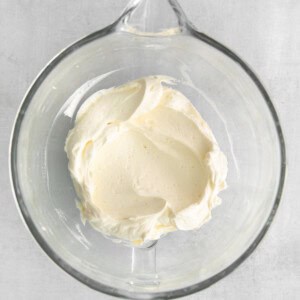 a glass bowl filled with cream on top of a table.