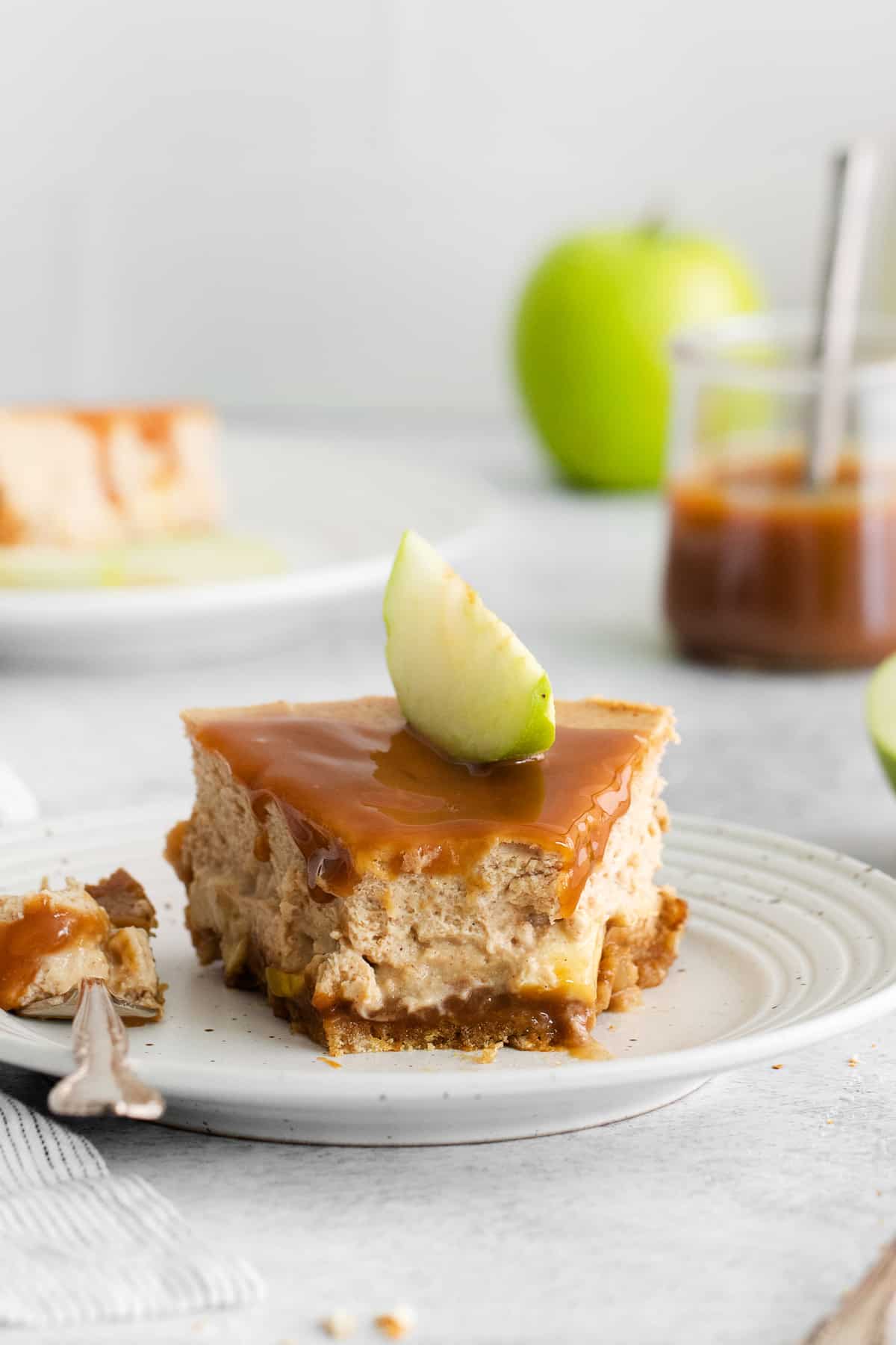 Slice of caramel apple cheesecake on a plate.