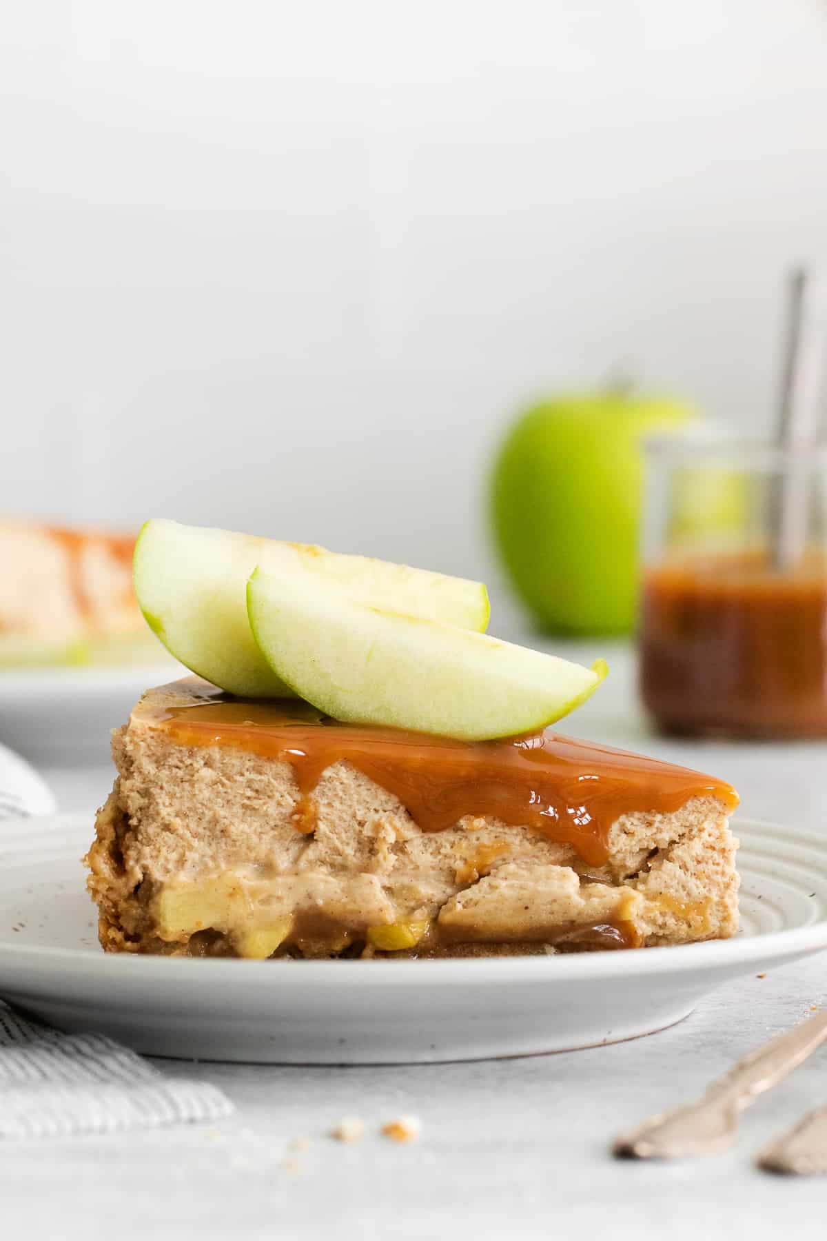 Slice of caramel apple cheesecake on a plate.