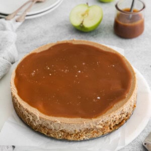 a chocolate caramel cheesecake on a white plate.