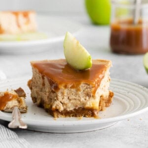 a piece of cheesecake with caramel sauce on a plate.