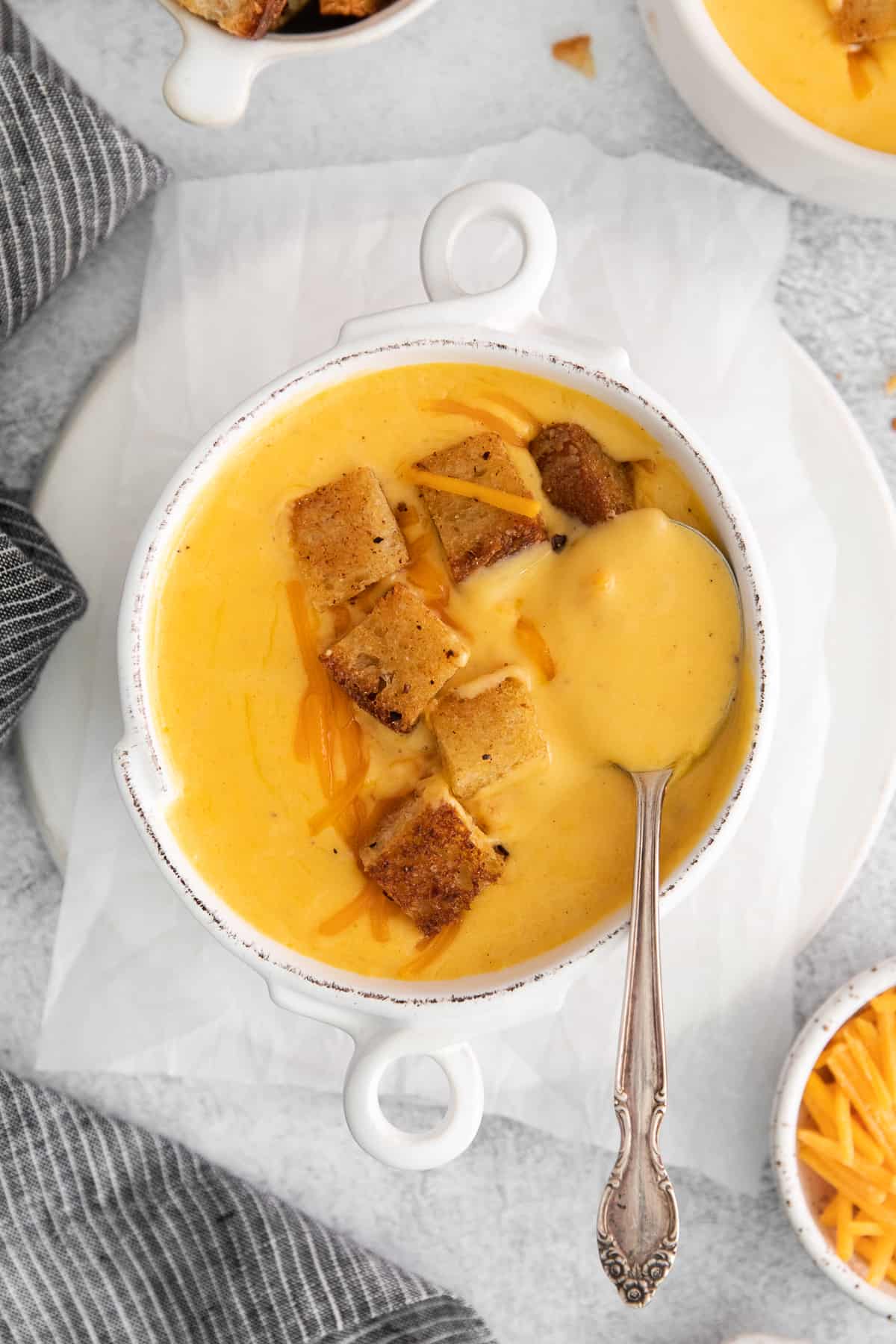 Cheddar cheese soup in a bowl with a spoon.