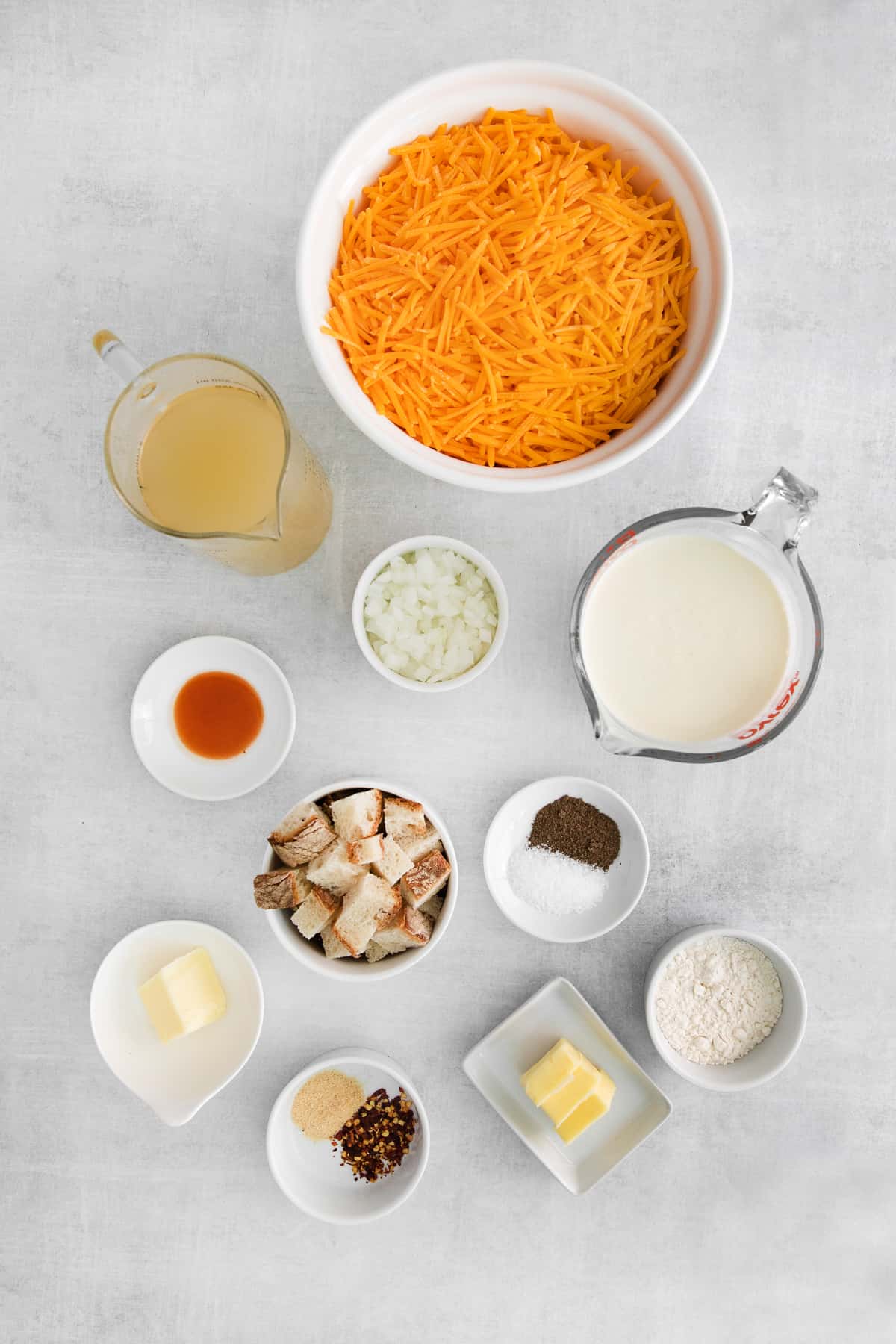 Ingredients for cheddar cheese soup in bowls.