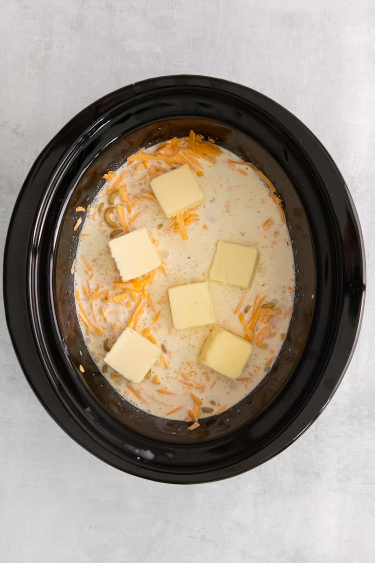 milk, butter, and cheese in crock pot.