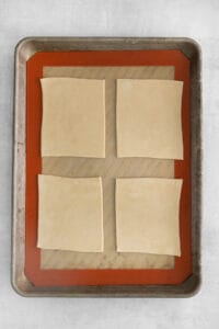 four squares of dough on a baking sheet.
