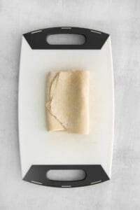a piece of dough on a cutting board.
